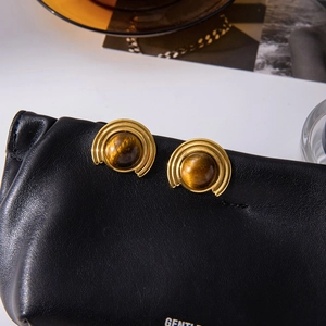 Detail of vintage gold stud earrings with natural tiger eye stone in concentric circles