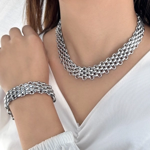 Macro shot of silver heavy-duty multi-layer woven chain necklace and bracelet set