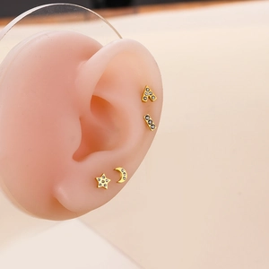 Golden stainless steel stud earrings set with star and moon zircon on mannequin ear