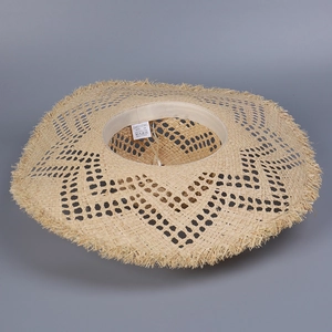 Handwoven beige raffia sun hat with wide brim, frayed edges and hollow texture for summer