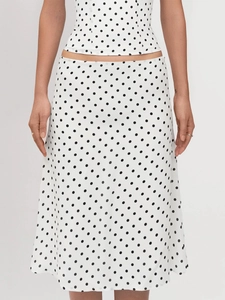 Detailed texture of white polka dot fabric on a two-piece halter top and mini skirt set