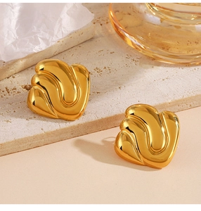Macro view of geometric 18K gold plated titanium steel earrings on a stone base