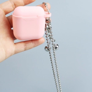 Pink silicone astronaut cherry keychain on silver metal chain held by hand on grey background
