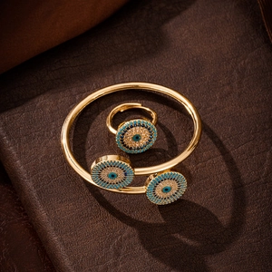 Exquisite gold-plated evil eye jewelry set featuring an open bangle and matching ring