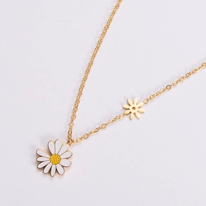 Golden daisy flower pendant necklace with white enamel petals on a minimal white background