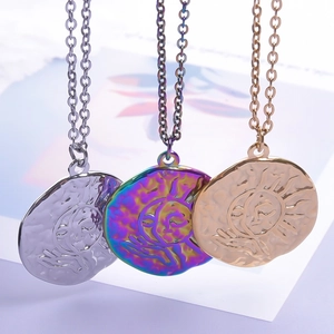 Detail view of round sun relief pendants in silver, rainbow, and gold vacuum plated steel