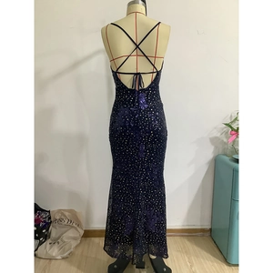 Detail of cross-back straps on a navy sequin evening gown with starry floral patterns