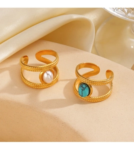 Detailed view of gold-layered open rings featuring white pearl and turquoise stone accents