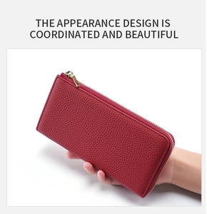 Detail of red genuine leather long wallet showing pebbled texture and smooth metal zipper