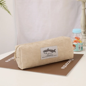 Close-up of beige corduroy stationery bag with shark embroidery patch and metal zipper
