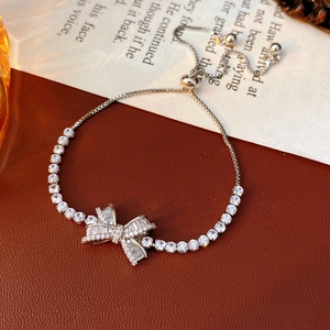 Detailed view of silver bow bracelet with zircon stones and adjustable chain