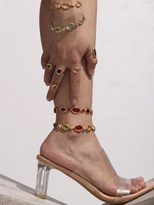 Detailed close-up of Bohemian gold bracelet with colorful Czech glass gems on a wrist