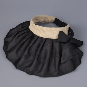 Detailed close-up of sun hat featuring satin jacquard pattern and large black bow decoration