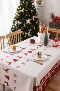 Close-up detail of waterproof Christmas tablecloth with red reindeer and snowflake patterns