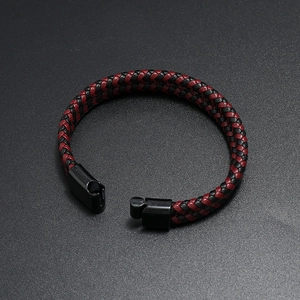 Dettaglio macro del bracciale in pelle intrecciata rosso nero con chiusura magnetica nera