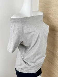 Detailed texture of grey off-shoulder t-shirt fabric on a side view model