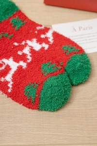 Nahaufnahme der flauschigen Weihnachts-Socken aus korallenrotem Vlies für warme Füße