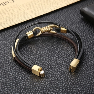 Détail du bracelet multicouche en cuir tressé avec crochet métallique doré et fermoir vintage