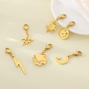 Detail of assorted gold stainless steel charms including star, moon and lightning designs