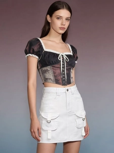 Detail of a white cargo denim skirt with utility pockets and a slim high waist fit