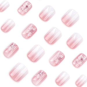 Pink and white gradient press-on nails with white floral patterns on white background