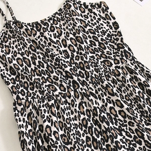 Detail of leopard print jumpsuit featuring thin straps and pleated neckline stitching