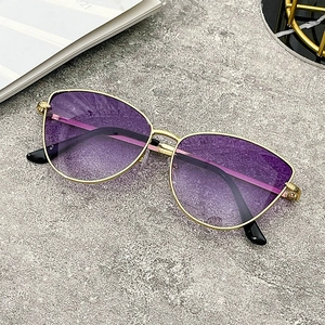 Detail of purple gradient resin lenses and sleek gold metal frame of cat-eye sunglasses