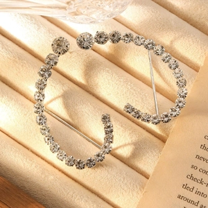 Eleganti orecchini geometrici curvi argentati con strass su vassoio in velluto