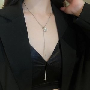 Detail of minimalist silver snake chain necklace with pearl pendant on model
