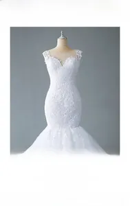 Detailed view of white mermaid bridal gown featuring floral lace embroidery and illusion neckline