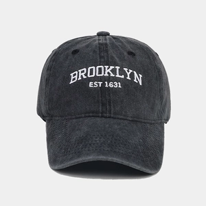 Close-up of white Brooklyn embroidery on washed dark grey vintage cotton baseball cap