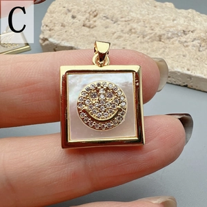 Detailed view of square gold pendant with mother of pearl and zircon smiley face