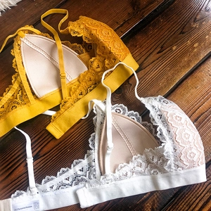 Vue détaillée de l'ensemble bralette en dentelle jaune et blanche sur fond bois