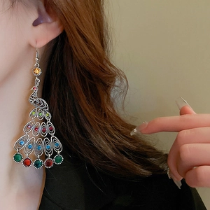 Detail of vintage peacock drop earring featuring colorful rhinestones and silver alloy