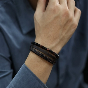 Close-up of men's multilayer bracelet featuring red tiger eye beads and braided leather cords
