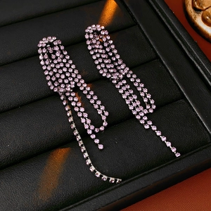 Detailed macro view of pink rhinestone geometric teardrop tassel earrings on display