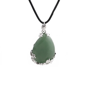 Macro shot of silver-edged green teardrop gemstone pendant with a black cord necklace