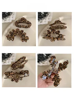 Detailed close-up showing the interior metal spring and leopard print texture of hair claw clips