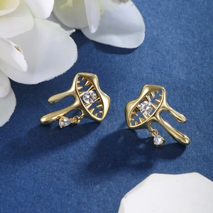 Detail of gold fluid star earrings with sparkling round and teardrop zircon crystals