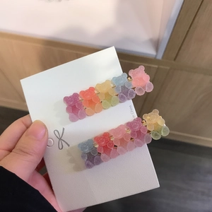 Close-up of gradient rainbow gummy bear hair clips with sugary frosted texture and gold base