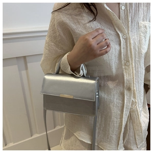 Silver metallic crossbody bag for women with top handle and slim strap shown on model