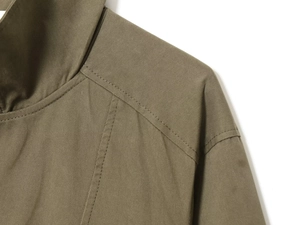 Detail of shoulder stitching and twill texture on army green high-collar jacket