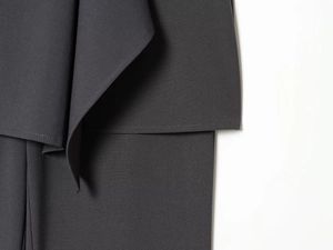 Detailed view of dark grey premium fabric with expert tailoring and layered hem design