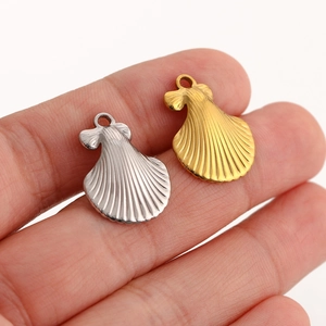 Macro detail of gold and silver seashell pendants with textured surface for DIY jewelry