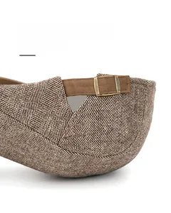 Detail of adjustable stainless steel buckle on herringbone wool flat cap for custom sizing