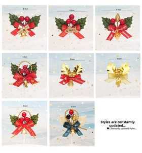 Detail of Christmas cake toppers with festive berries, bells, and Merry Christmas text