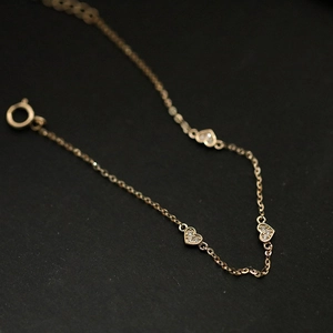 Macro detail of gold S925 sterling silver heart bracelet with sparkling diamond inlay