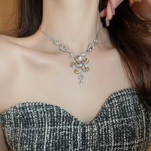 Detailed view of luxury silver flower pendant necklace with teardrop crystals on model