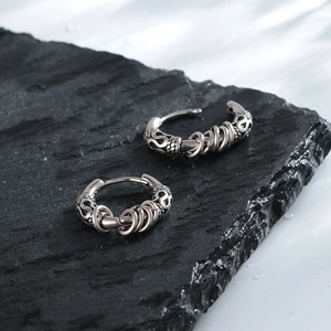 Detailed macro view of vintage silver earrings with floral engraving and metal rings