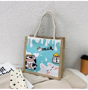 Detail of blue milk print canvas and jute tote bag with rope handles and rustic texture